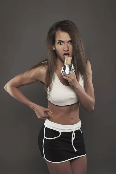 Woman  with diet bar on dark background studio shot — Stock Photo, Image