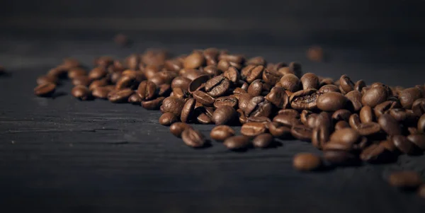 Grãos de café em um preto velho efeito de borrão de madeira bg — Fotografia de Stock