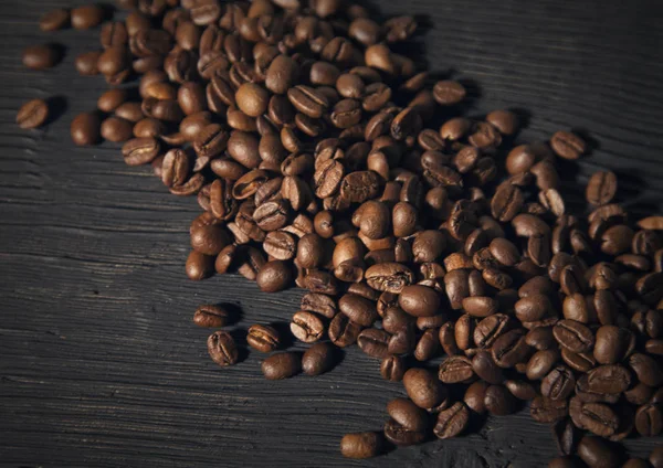 Kaffeebohnen auf einem schwarzen alten Holzbg — Stockfoto