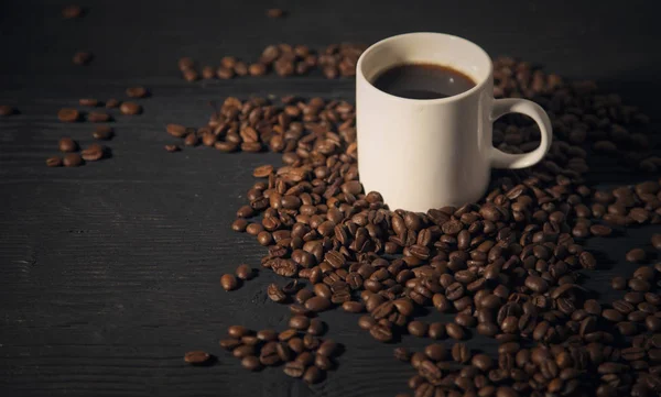 Grãos de café copo branco em um preto velho bg de madeira foto — Fotografia de Stock