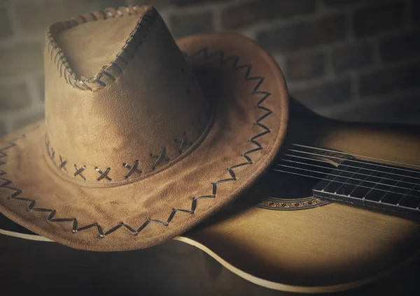 Hat cowboy and guitar on wall  brick light effect photo — Stock Photo, Image