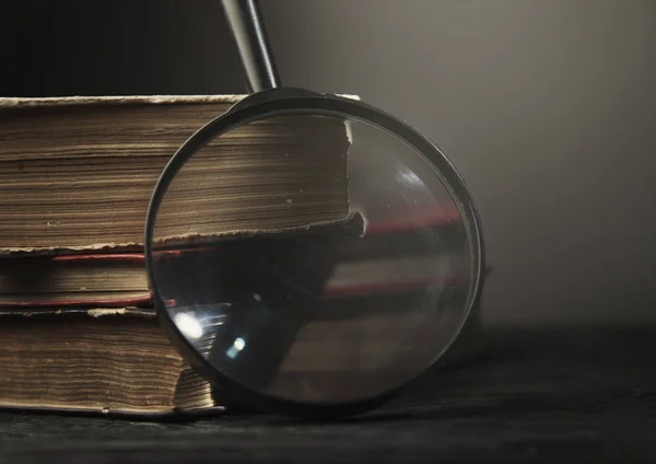 Три старые книги со стеклом на деревянной бумаге — стоковое фото
