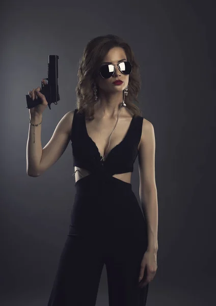 Красуня молода жінка з пістолетом студії моди знімок на темному бг — стокове фото