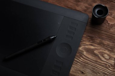 Tablet kahverengi ahşap bir fotografta yatıyor.