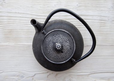 Ahşap arka planda siyah bir çaydanlık.