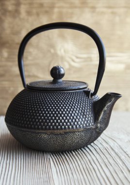 Ahşap bir arka planda siyah bir çaydanlık kapat.