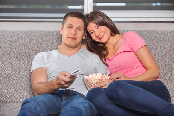 Młoda para jedzenie popcorn i oglądania — Zdjęcie stockowe
