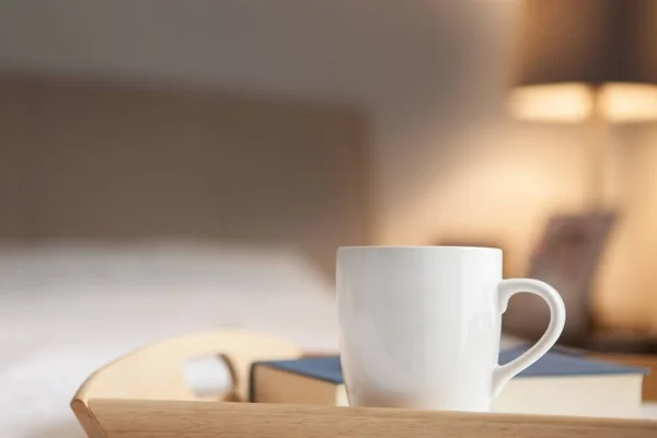 Tazza di bevanda calda e prenota sul letto — Foto Stock