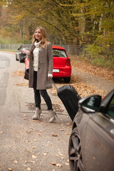 Mulher com bagagem chama um táxi — Fotografia de Stock