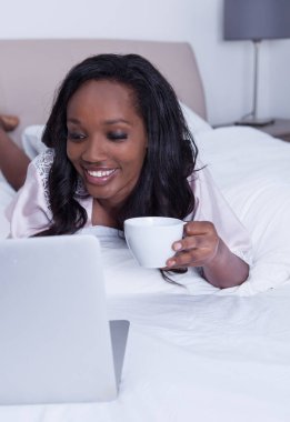 Yatakta bilgisayarla çalışan kız