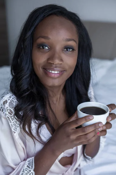 Woman is drinking coffee in bed — Stock Photo, Image