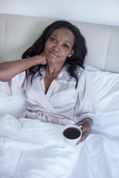 Woman is drinking a coffee in bed — Stock Photo, Image