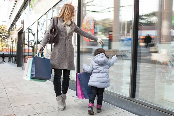 Mor med dotter går och handlar — Stockfoto