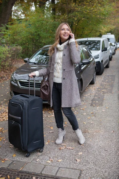 Mulher com bagagem chama um táxi — Fotografia de Stock