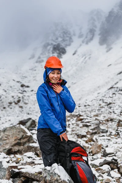 Женщина в шлеме с рюкзаком на Snow Covered Mountain Top Наслаждаясь видом . — стоковое фото