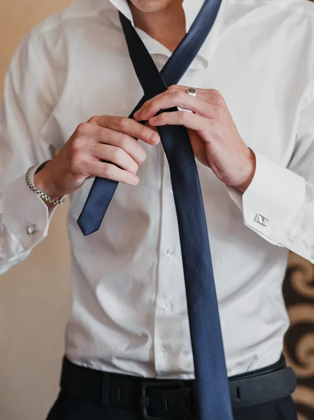 the man straightens his tie