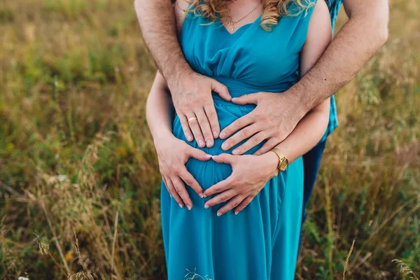 Gros plan main de l'homme sur le ventre de sa femme enceinte — Photo