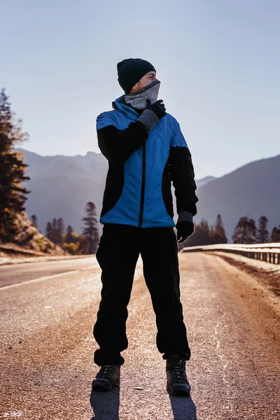 Homem andando por uma estrada de montanha — Fotografia de Stock