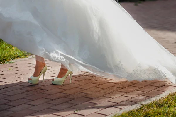 Krásná nevěsta boty s dlouhýma nohama v bílých svatebních šatech — Stock fotografie