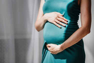 Karın üzerinde elleriyle tanınmaz halde hamile karnına Close-Up