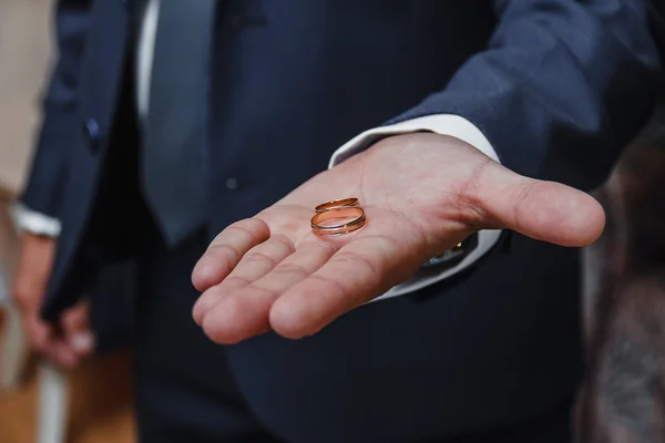 Trouwringen op de palm van de bruidegom, huwelijk voorstel. — Stockfoto