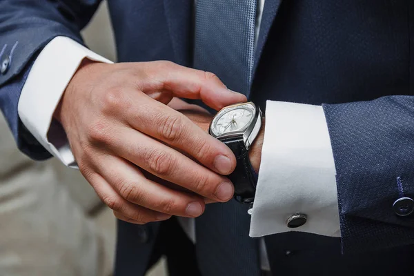 Nahaufnahme eines eleganten Mannes im Anzug, der mit Uhr die Zeit kontrolliert — Stockfoto