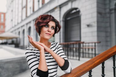 Portre yakın çekim genç güzel esmer kadının saç ve makyaj, Bahar sokak arka plan ile