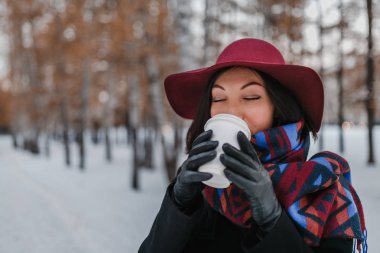 Büyük bir fincan sıcak paket servisi olan restoran içecek soğuk gün boyunca kadınla. Geniş ekledi şapka ve parlak eşarp giymiş