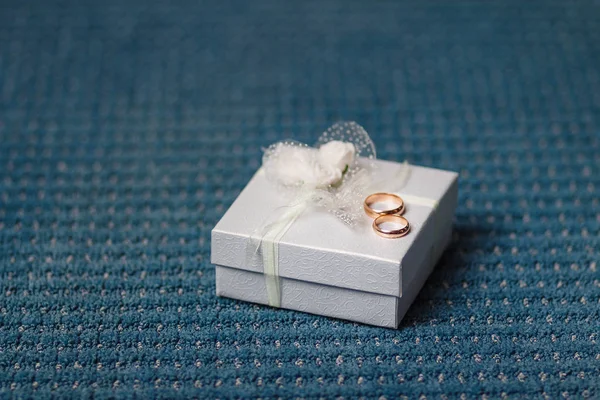 Goldene Eheringe auf der weißen Geschenkbox — Stockfoto