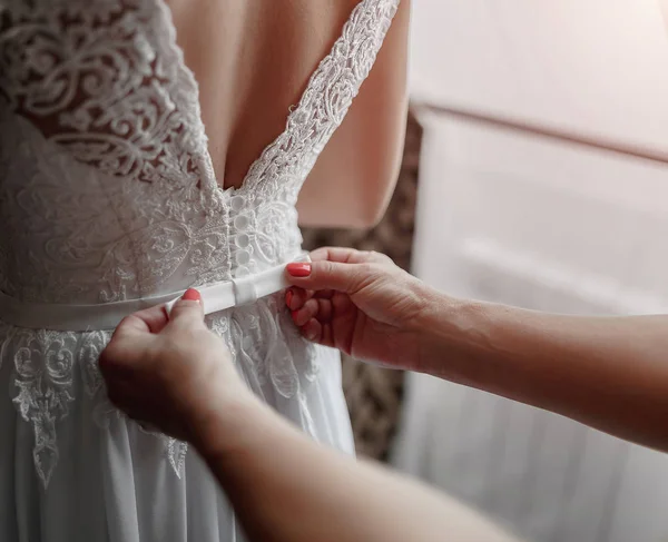 Mãos closeup amarração acima vestido de casamento espartilho — Fotografia de Stock