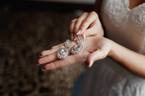 Pendientes de boda en una mano nupcial, la mañana de la novia y accesorios de joyería y concepto de decoración —  Fotos de Stock