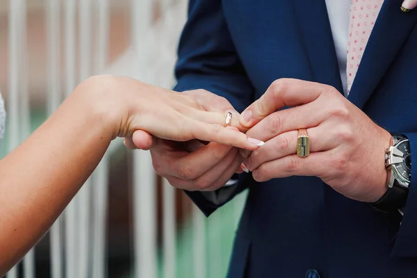 Brudgummen hand sätta en vigselring på bruden finger utomhus — Stockfoto