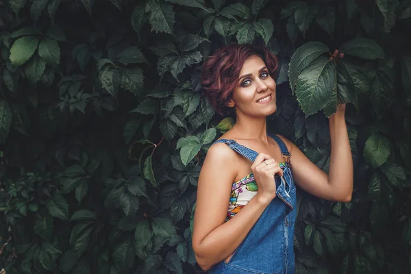 Sarmaşık duvar yeşil yaprakları ile bir arka plan üzerinde çekici bir genç şehvetli kadın portresi — Stok fotoğraf