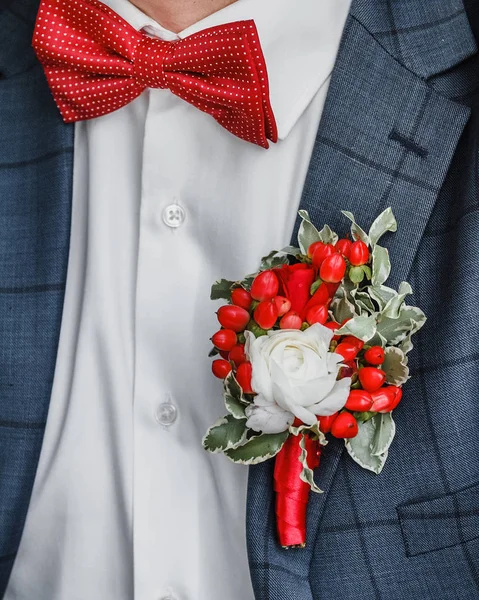 Наречені з червоною краваткою і червоною трояндою бутоньєрки на день весілля — стокове фото