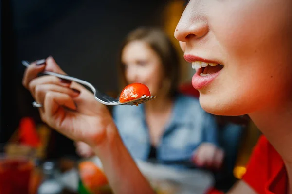 Kobieta z widelcem w jamie ustnej z pomidorem cherry — Zdjęcie stockowe