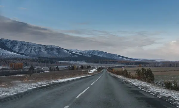 Estrada vazia no campo com árvores no final do outono com sno — Fotografia de Stock