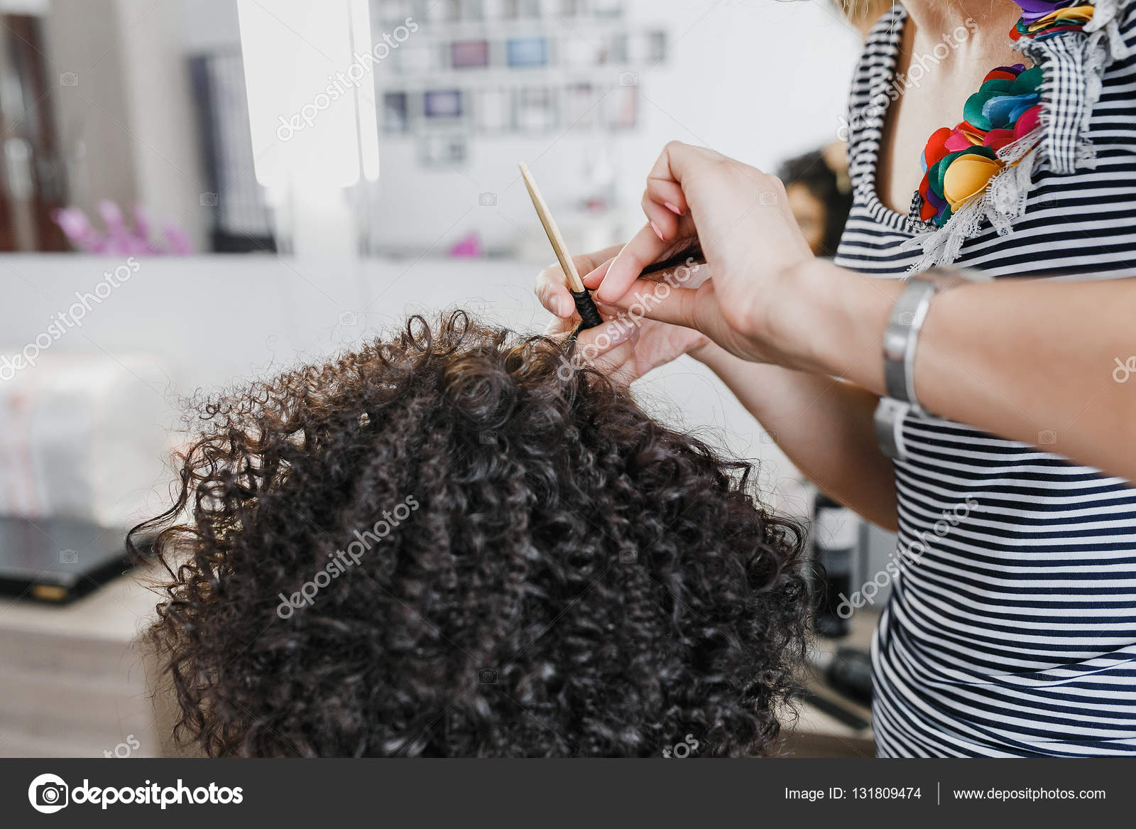 Close Up Of A Hairdresser Curling Short Black Hair With Hair Irons