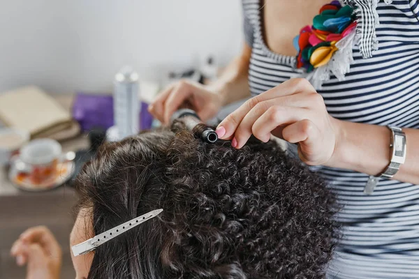 Close-up de um cabeleireiro curling cabelo preto curto com ferros de cabelo . — Fotografia de Stock