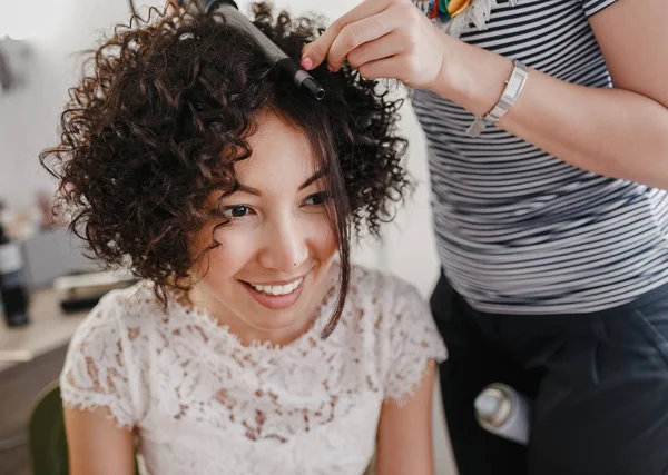 Menina morena com cabelo curto encaracolado saudável escuro no salão de cabeleireiro, fazendo coiffure — Fotografia de Stock