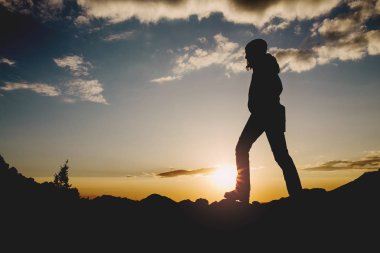 Bir güzel uzun yürüyüşe çıkan kimse kız günbatımı üzerinde atlama silüeti