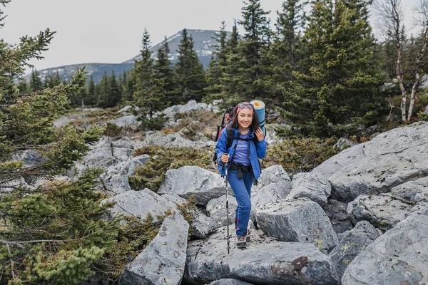 Senderista joven con mochila recorriendo un sendero en montañas rocosas — Foto de Stock