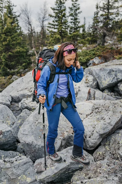 Mujer excursionista es trekking en las montañas entre el campo de piedras y rocas. Sendero a pico alto — Foto de Stock