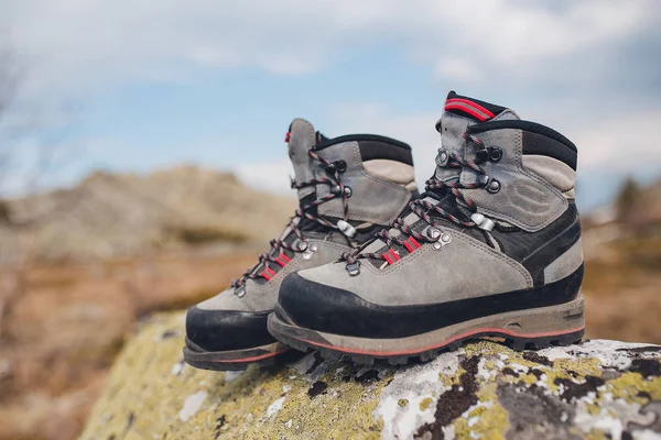 Botas cinza desgastadas deixadas na pedra, no alto das montanhas — Fotografia de Stock