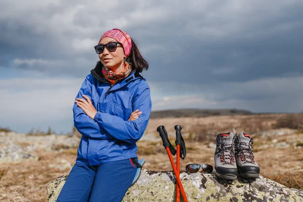 Mujer senderismo en las montañas con zapatos y bastones de trekking en las montañas —  Fotos de Stock