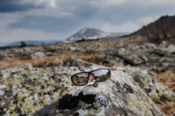 Sluneční brýle na kámen v horách, cestování koncept — Stock fotografie