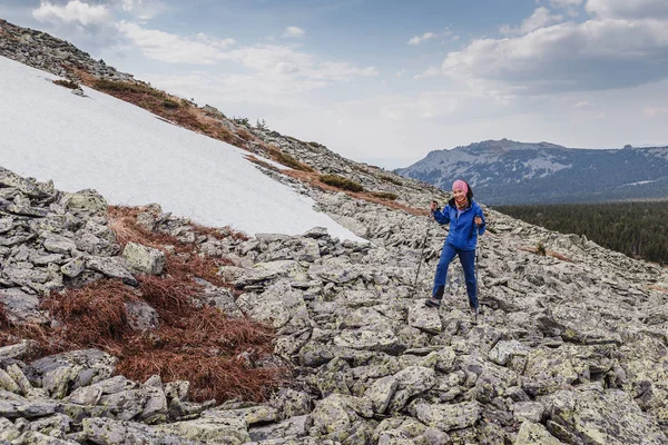 Jovem viajante feliz sobe a montanha com poste de trekking. Conceito de estilo de vida saudável e desportivo . — Fotografia de Stock