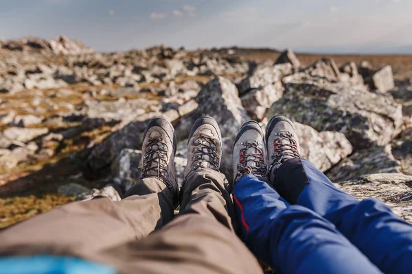 Travelers couple with hiking boots on mountain top. Feet selfie.