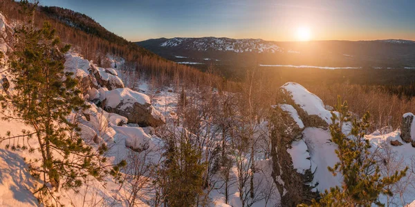 Krásné Ural zimní krajina s zapadajícího slunce za hory, zasněžené lesy a skály — Stock fotografie