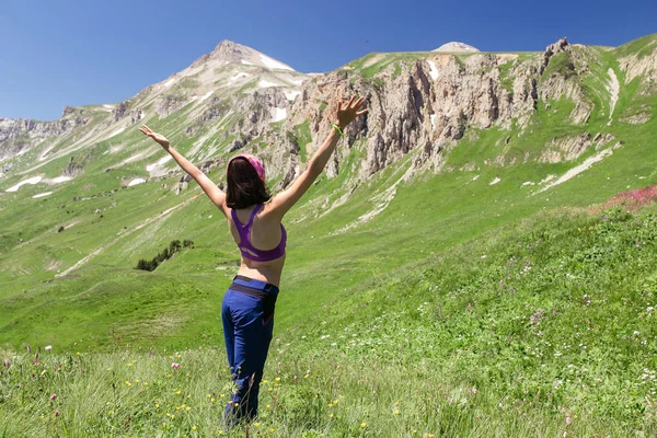 Mujer en un prado de montaña en verano en clima cálido . —  Fotos de Stock