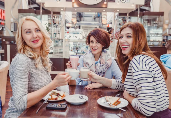Tři mladé ženy kamarádky mají přestávku na kávu. Koncepce setkání s přáteli a socializace — Stock fotografie
